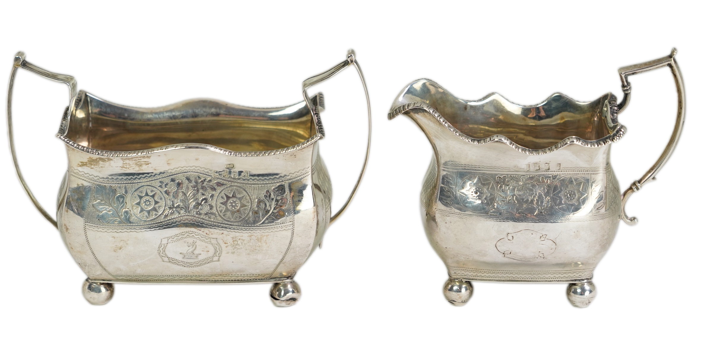 A George III Irish silver two handled sugar bowl, by Richard Sawyer, Dublin, 1808, 18.4cm over handles, with engraved armorial, on four ball feet, together with a similar cream jug, by Daniel Egan, Dublin, 1811, 16.2oz.